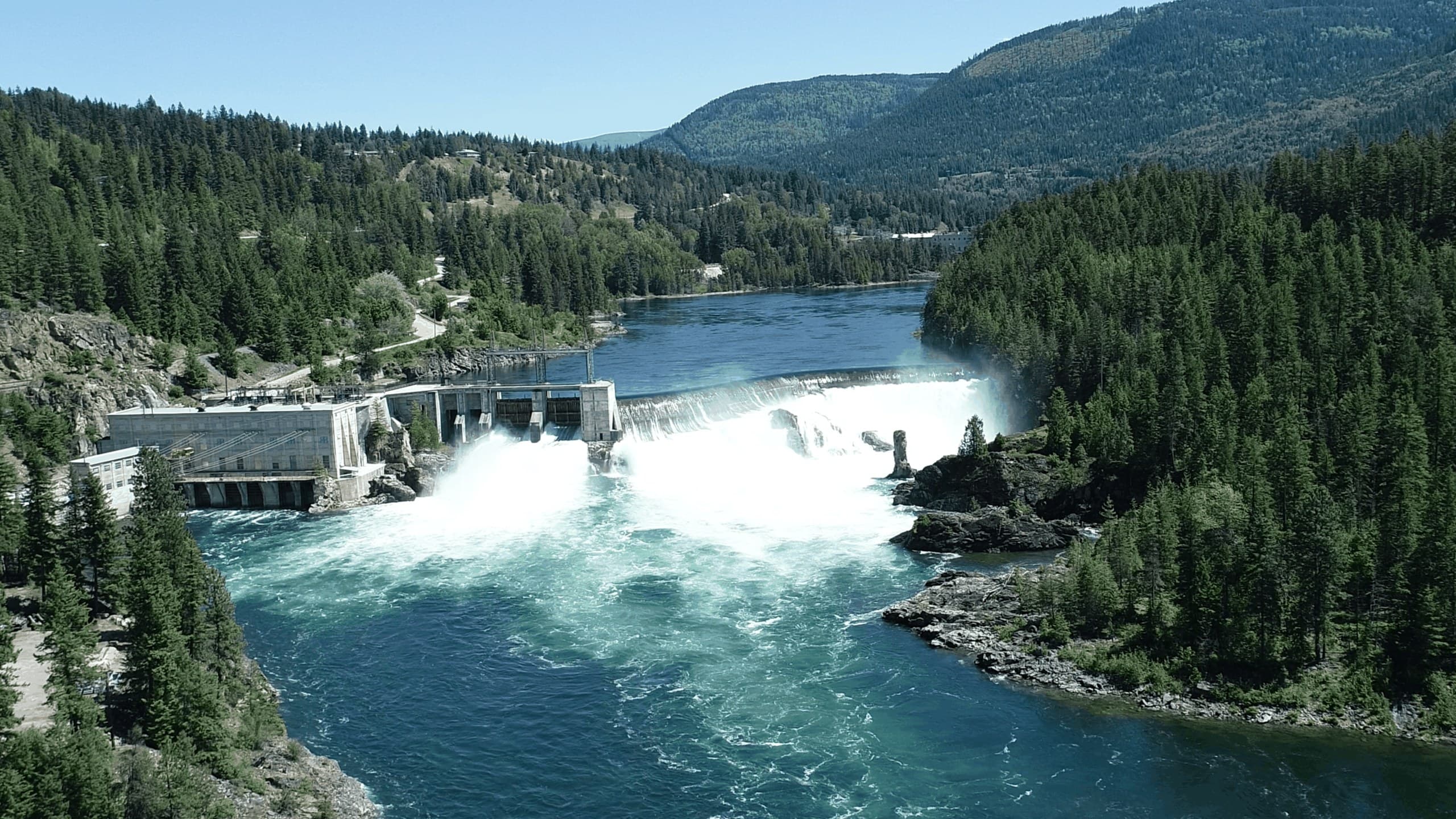 Aerial view of a dam spillway in full flow