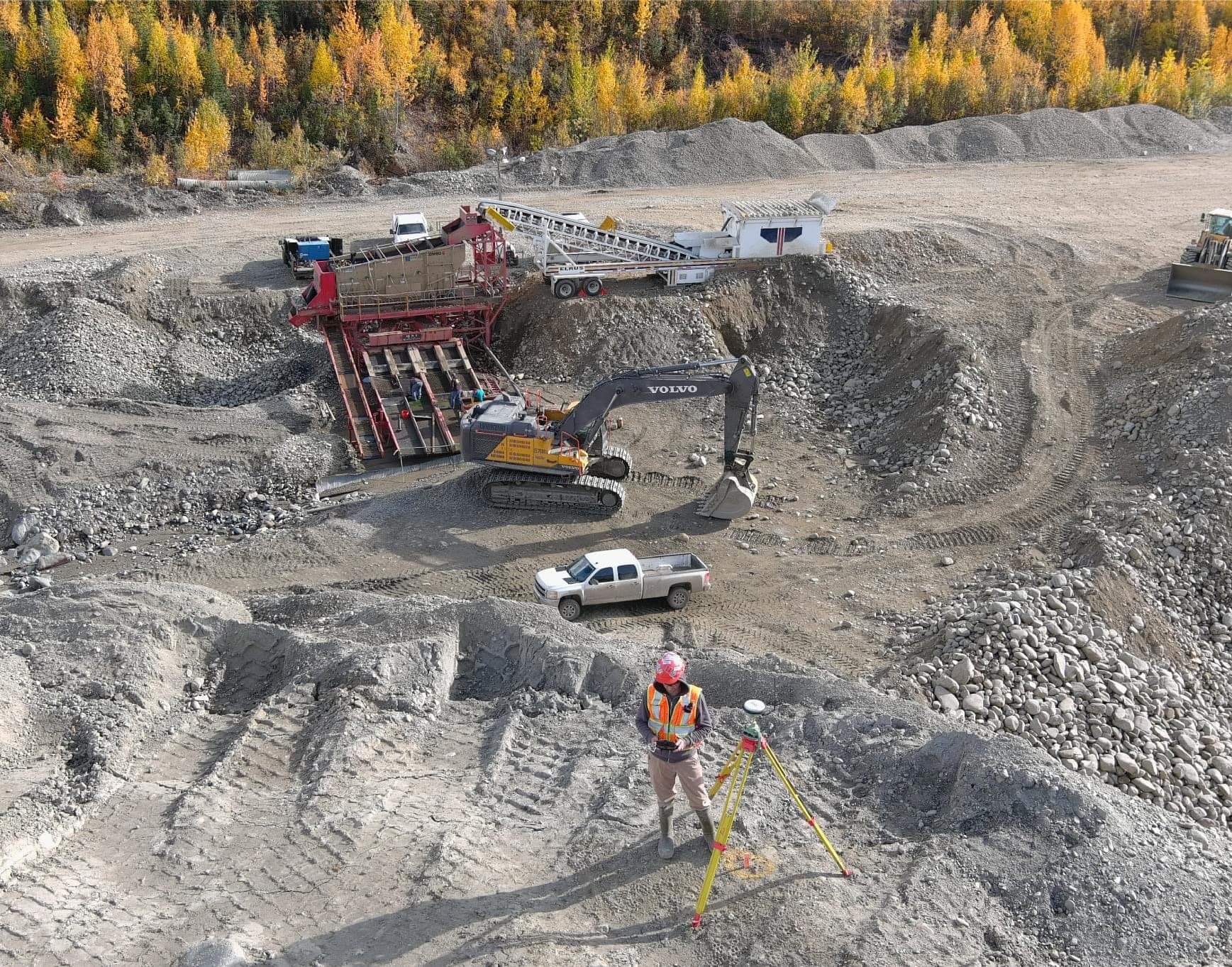 Aerial view of survey crew and excavators in a rock quarry
