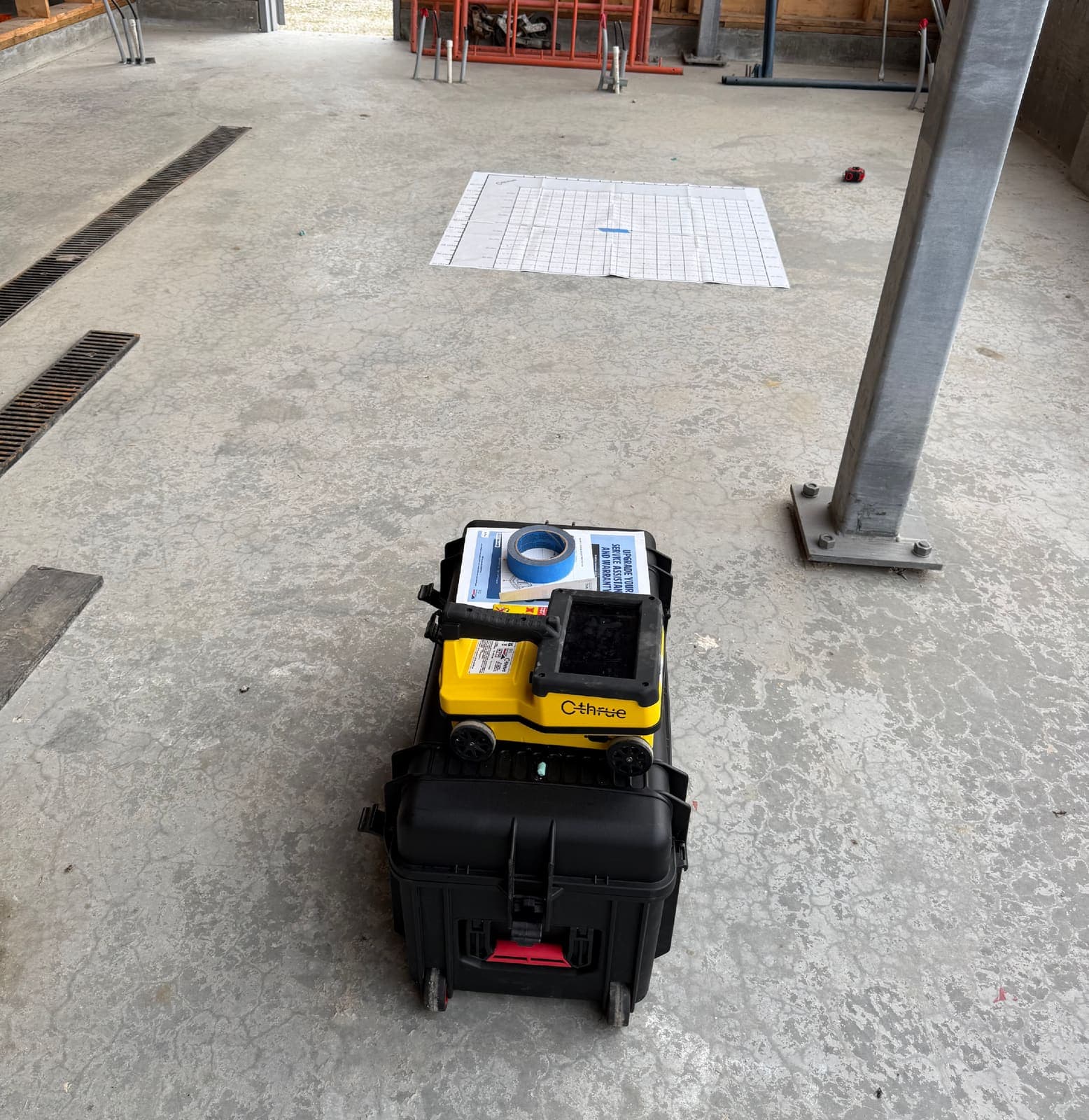 Concrete scanning equipment staged on site with the scan grid laid out on the slab