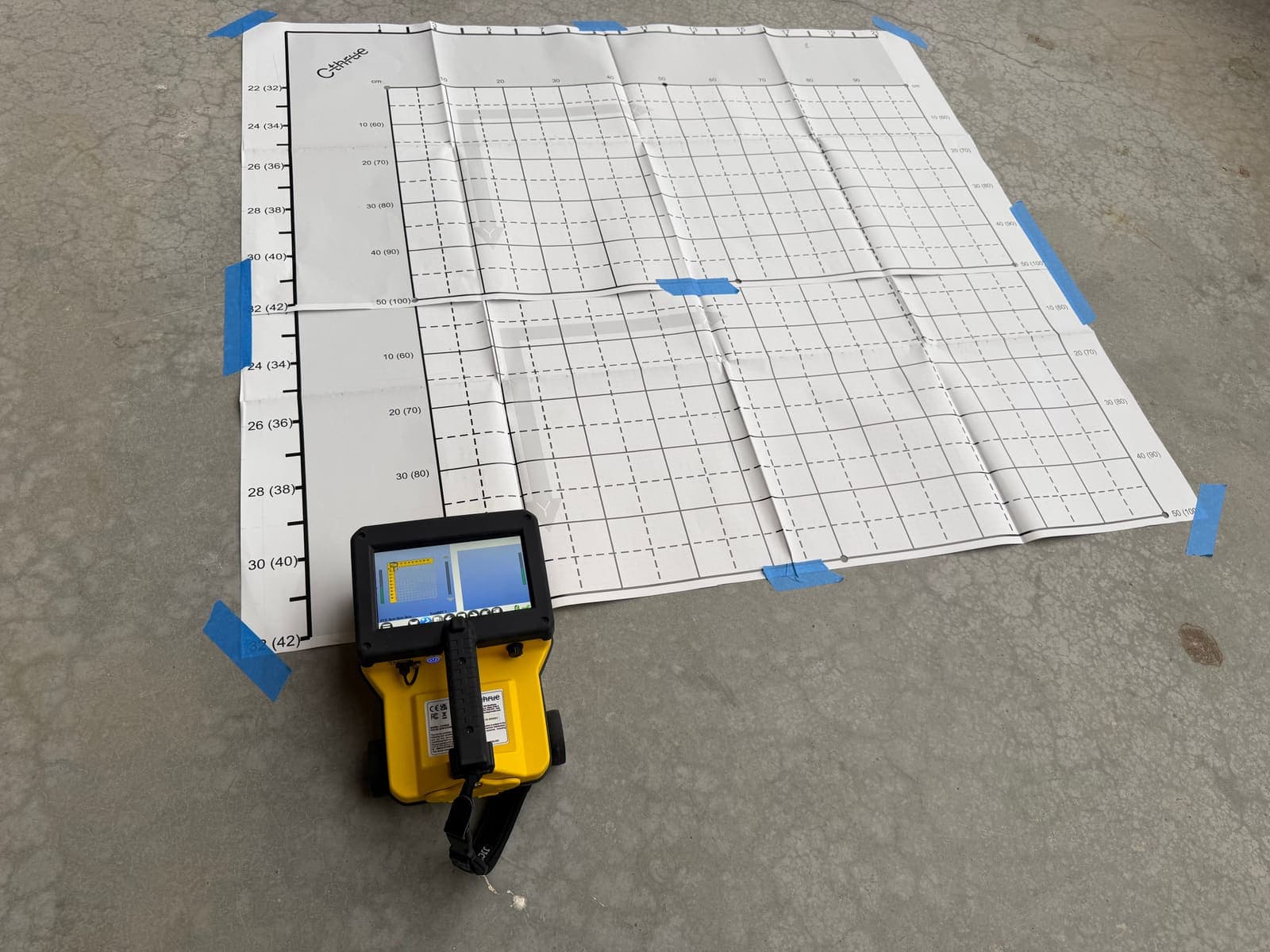 High-frequency concrete scanner on a grid mat, ready to scan a slab before cutting