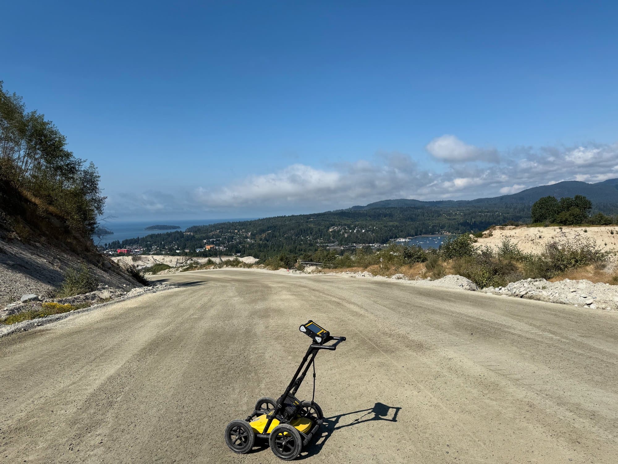 GPR cart on a gravel road overlooking a lake and valley