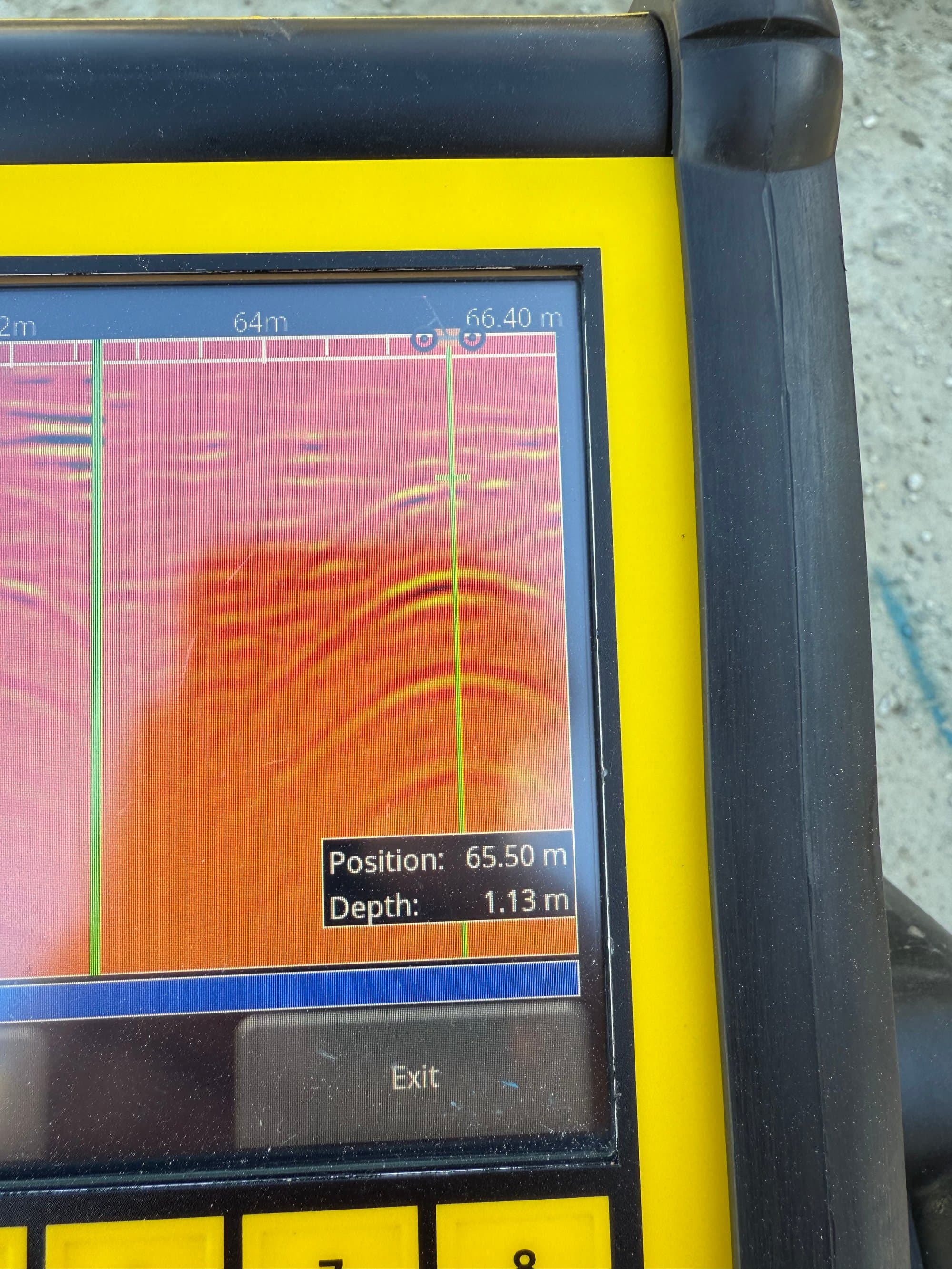 GPR readout showing a buried-utility hyperbola with position and depth