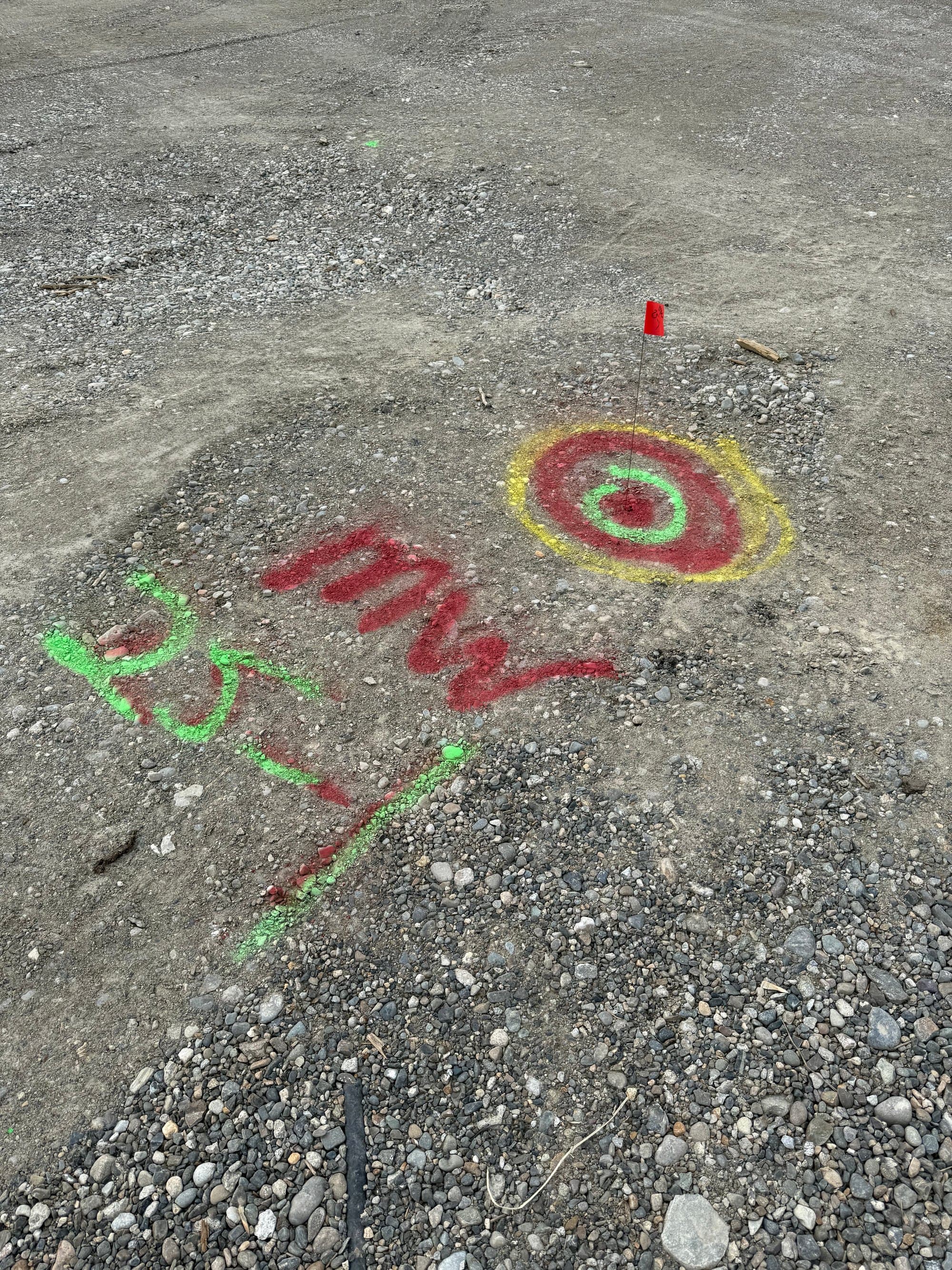 Paint-marked locate target with position and depth notes on pavement