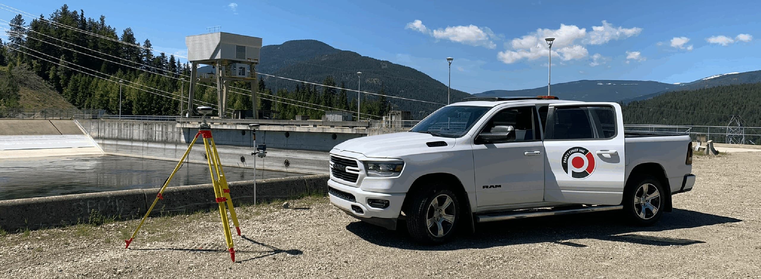Survey truck parked below a hydro dam