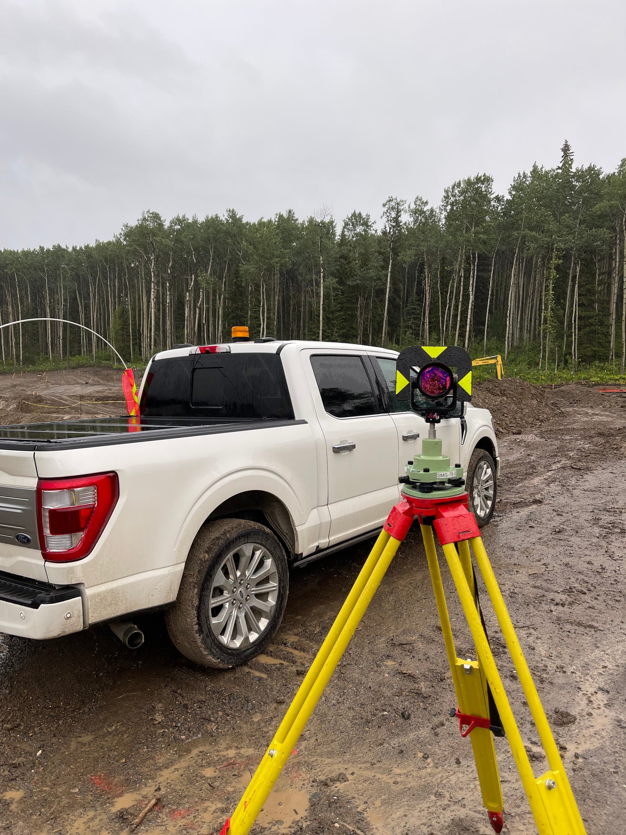 Survey truck and prism pole on site