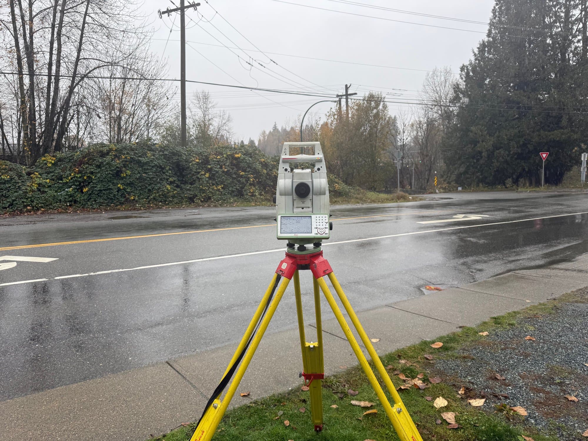Total station on a rain-soaked city street