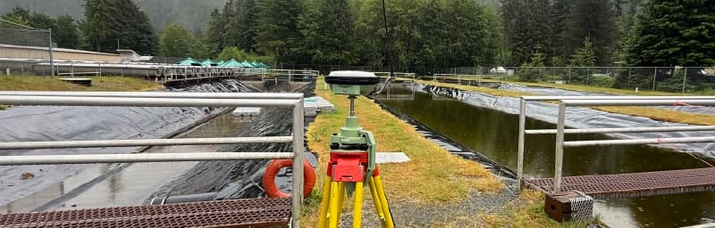 Commercial construction surveyor featured image showing GNSS setup on a commercial project in BC.