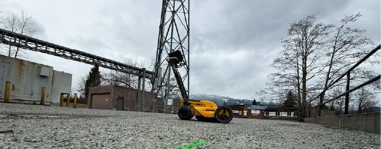 Private utility locating paint marks on gravel at an industrial site before construction and excavation.