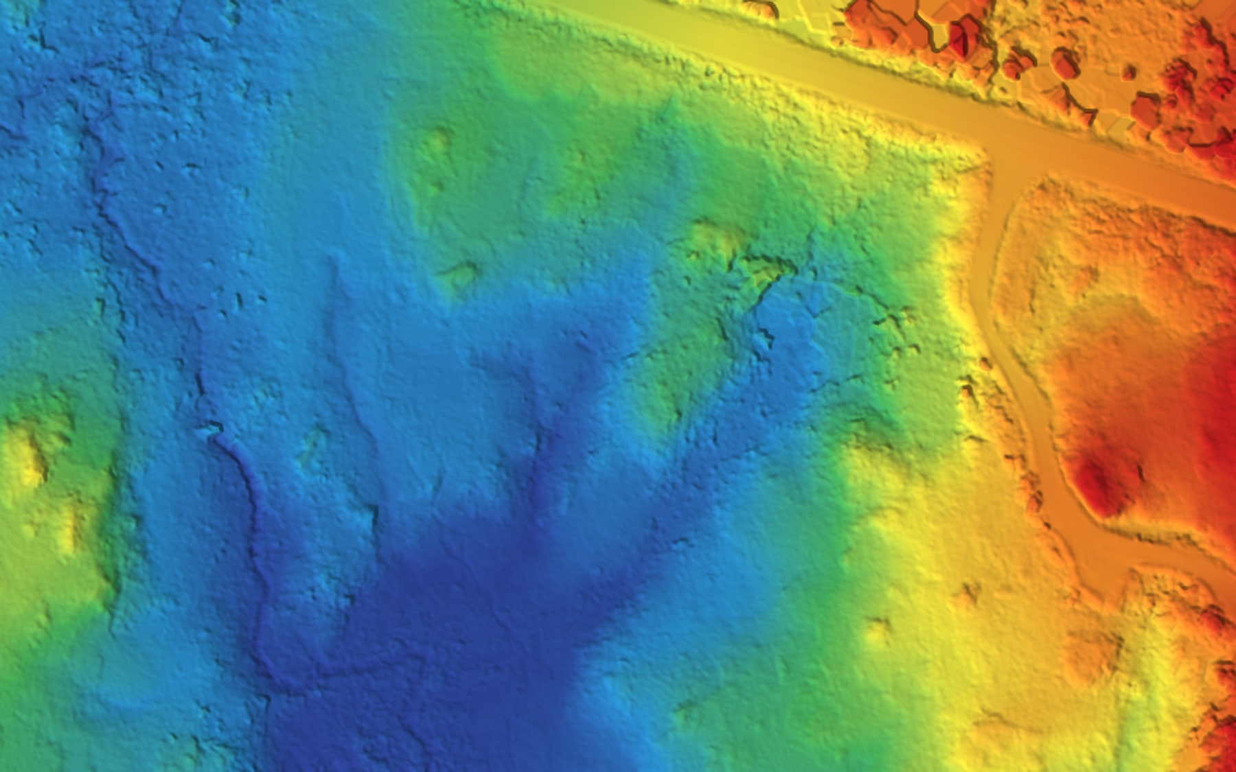 Bare-earth elevation model from a PCI drone LiDAR flight, coloured by height — highway, access road and drainage channels across a northern wetland