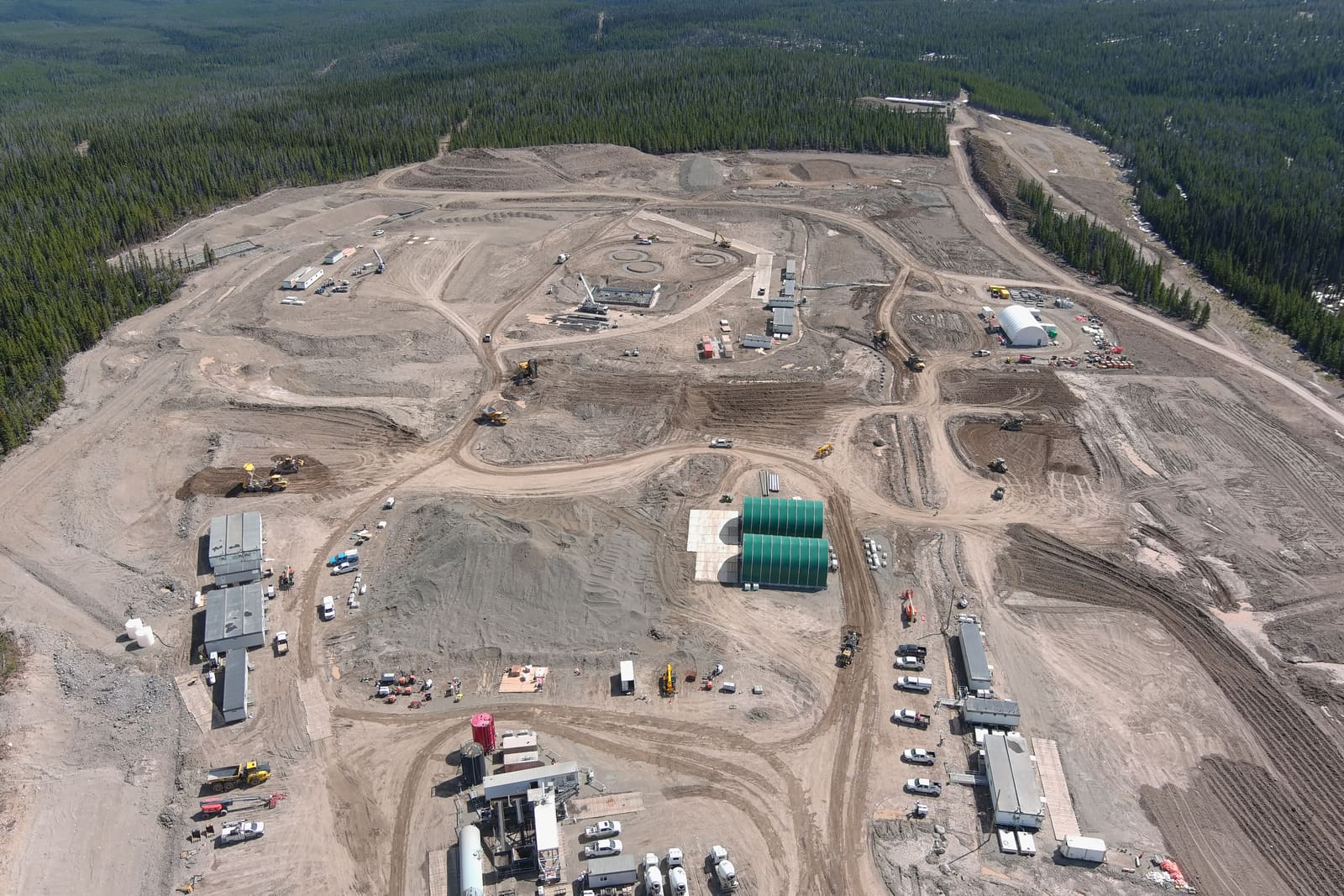 Aerial view of early mine site development — camp buildings, laydowns and earthworks cut into boreal forest