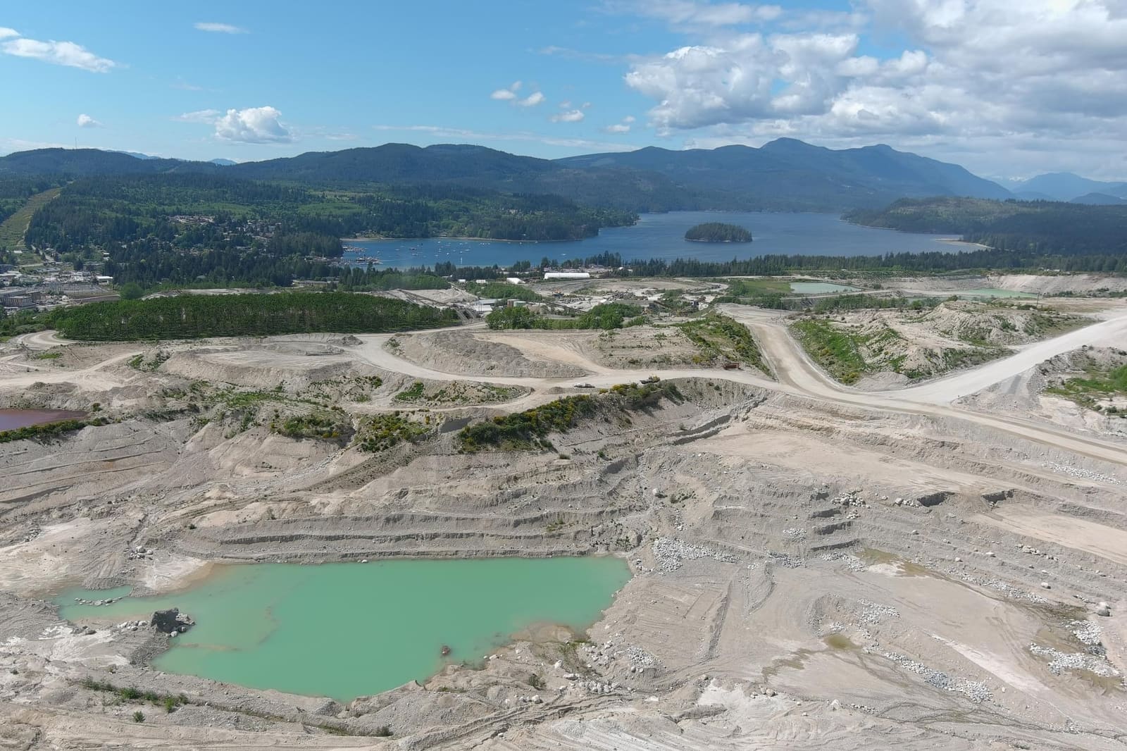 Aerial view of open-pit benches and a water management pond