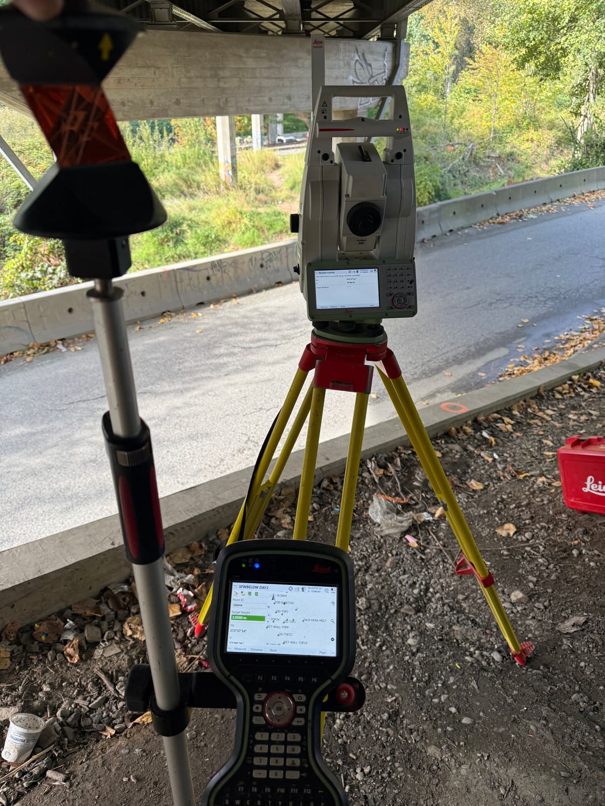 Prism pole on a concrete curb during civil layout beside a roadway