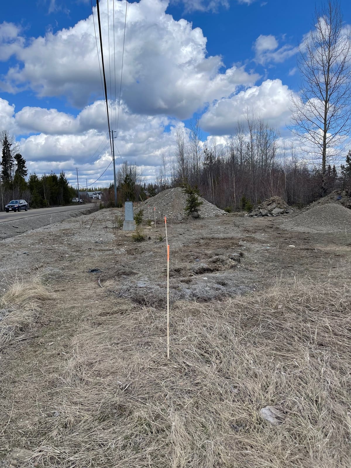 Staked and flagged gravel site ahead of earthworks