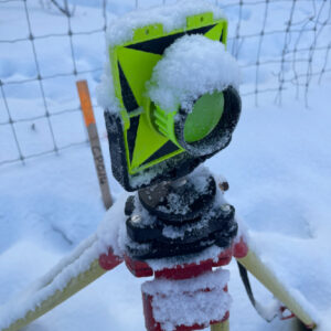 Construction surveyors actively working in Northern British Columbia, near the Alberta border. Our advanced surveying equipment stands prominently, with the rugged and scenic landscape of Northern BC serving as a striking backdrop, illustrating the blend of nature and development.