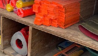 PCI's surveying tools and equipment stored in a truck bed, including wooden stakes, marking flags, traffic cones, hammer, level, and other field essentials.