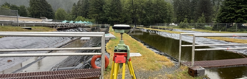 Commercial construction surveyor featured image showing GNSS setup on a commercial project in BC.