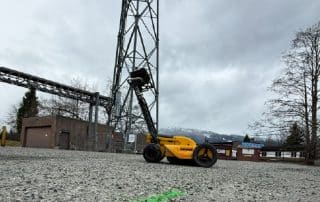 Private utility locating paint marks on gravel at an industrial site before construction and excavation.