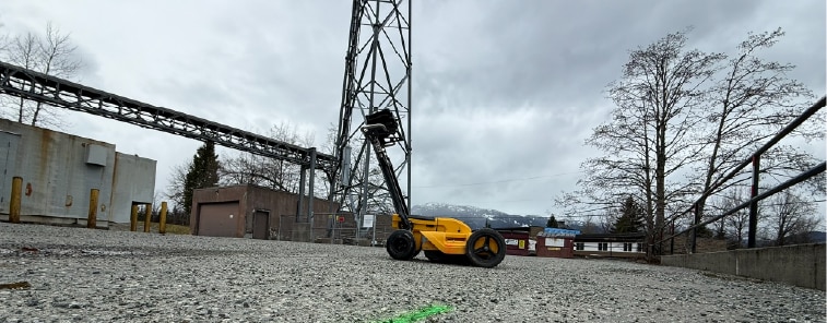 Private utility locating paint marks on gravel at an industrial site before construction and excavation.