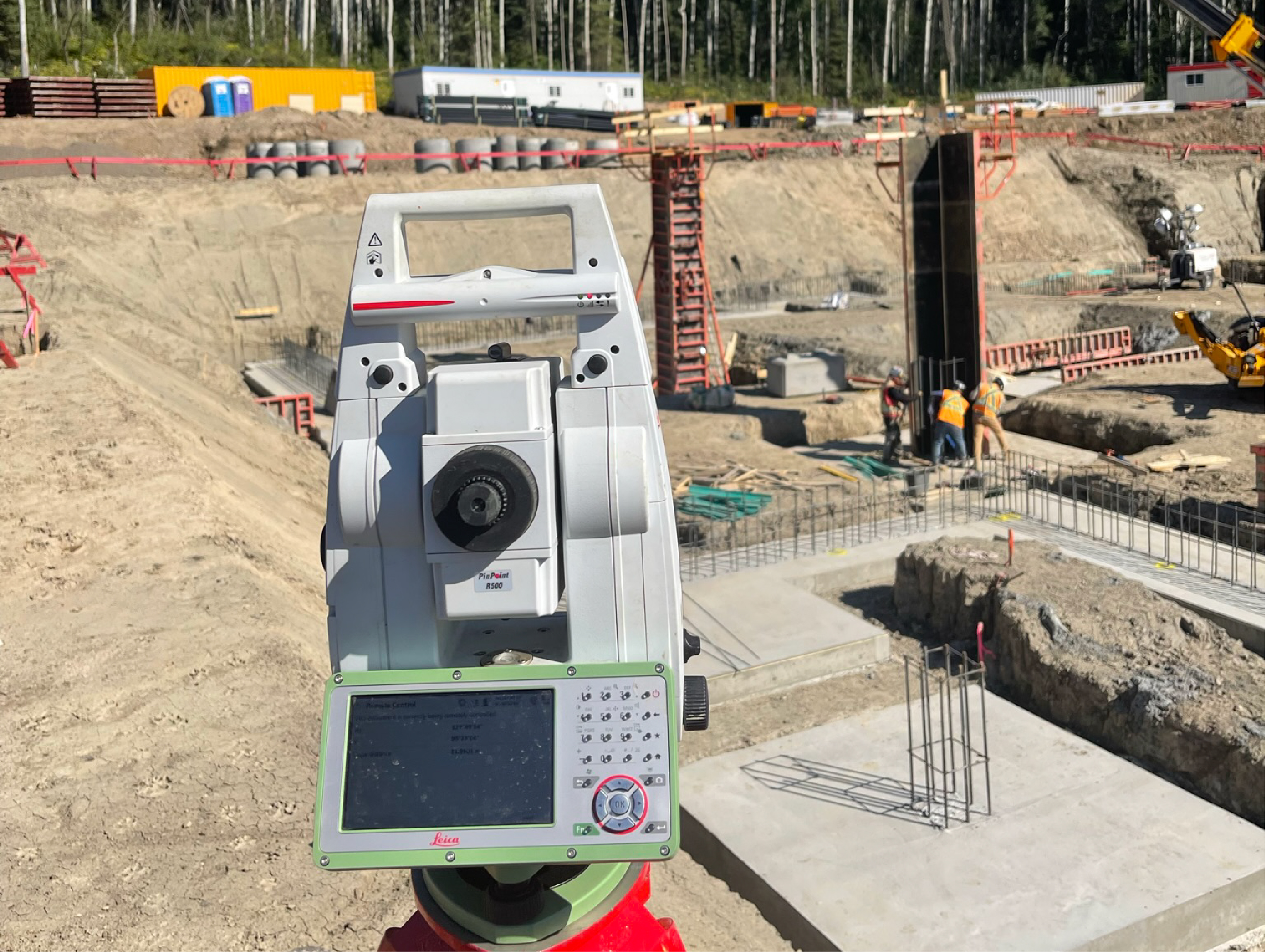 Construction surveying equipment on an active construction site for layout, control, and geomatics field work.